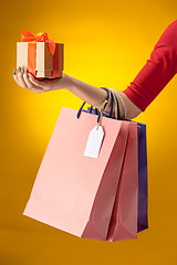 Image showing Female hand holding bright shopping bags