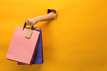 Image showing Female hand holding bright shopping bags