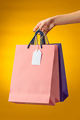 Image showing Female hand holding bright shopping bags