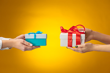Image showing The closeup picture of man and woman\'s hands with gift box