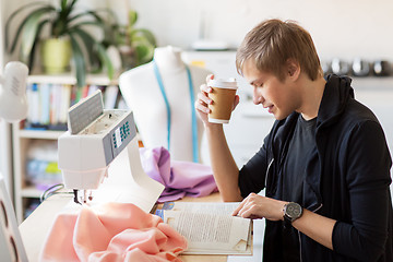 Image showing fashion designer with coffee and book at studio