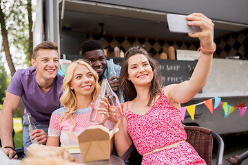 Image showing happy young friends taking selfie at food truck