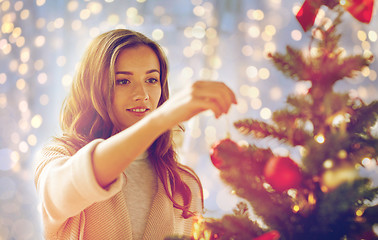 Image showing happy young woman decorating christmas tree