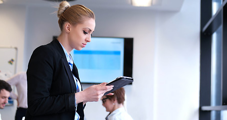 Image showing Businesswoman using tablet with coworkers in backgorund having m
