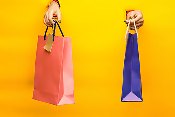 Image showing Female hand holding bright shopping bags