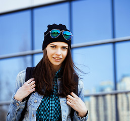 Image showing cute brunette teenage girl in hat, student outside at business building