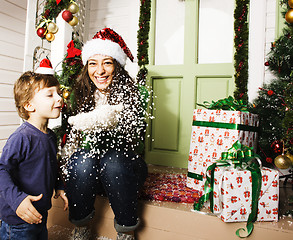 Image showing happy family on Christmas in red hats waiting gests and smiling outdoor