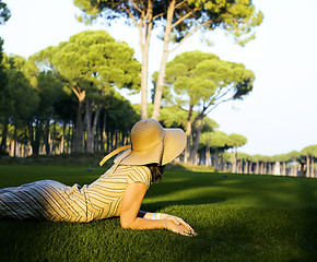 Image showing Beauty girl in hat on golf field at sunset