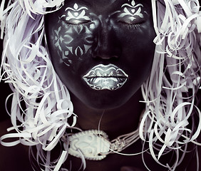 Image showing creative makeup like Ethiopian mask, white pattern on black face close up, halloween celebration