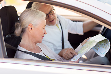 Image showing happy senior couple with map driving in car