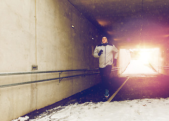 Image showing happy man running along subway tunnel in winter