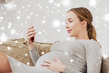 Image showing happy pregnant woman with smartphone at home
