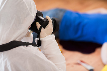 Image showing criminalist photographing dead body at crime scene