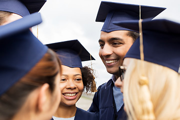 Image showing happy students or bachelors in mortar boards