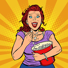 Image showing Woman watching a movie, smiling and eating popcorn