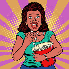 Image showing Woman watching a movie, smiling and eating popcorn