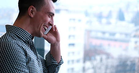 Image showing Business Man Talking On Cell Phone, Looking Out Office Window