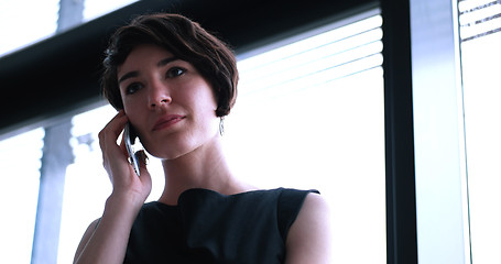 Image showing Business Girl Standing In A Modern Building Near The Window With