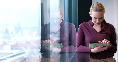 Image showing Pretty Businesswoman Using Tablet In Office Building by window