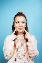 Image showing young pretty woman cheerful happy smiling, posing on blue background, lifestyle people concept 