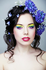 Image showing Beauty young woman with flowers and make up close up, real sprin