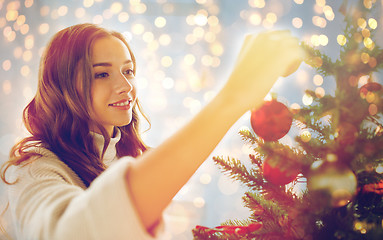 Image showing happy young woman decorating christmas tree