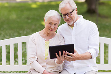 Image showing happy senior couple with tablet pc at summer park