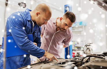 Image showing auto mechanic with clipboard and man at car shop