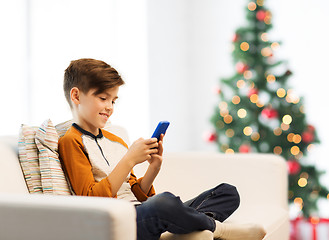 Image showing boy playing on smartphone at home at christmas