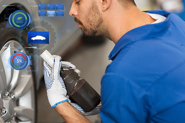 Image showing mechanic with screwdriver changing car tire