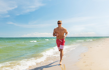 Image showing happy man running along summer beach