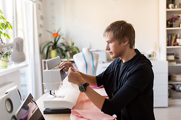 Image showing fashion designer with sewing machine at studio