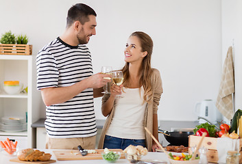 Image showing couple cooking food and drinking wine at home