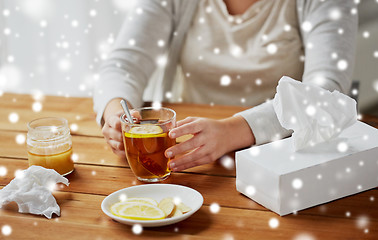 Image showing close up of ill woman drinking tea with lemon