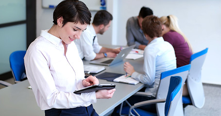 Image showing Businesswoman using tablet with coworkers in backgorund having m