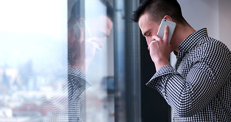 Image showing Business Man Talking On Cell Phone, Looking Out Office Window