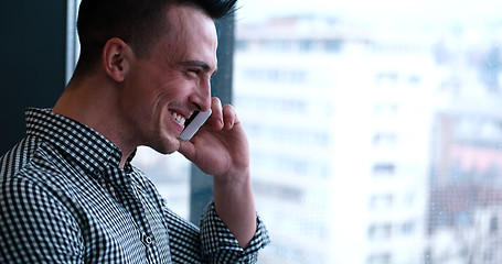 Image showing Business Man Talking On Cell Phone, Looking Out Office Window