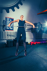 Image showing Fit young woman lifting barbells working out in a gym