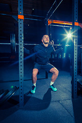 Image showing Portrait of super fit muscular young man working out in gym with barbell