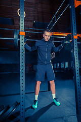 Image showing Portrait of super fit muscular young man working out in gym with barbell