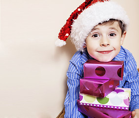 Image showing little cute boy with Christmas gifts at home. close up emotional