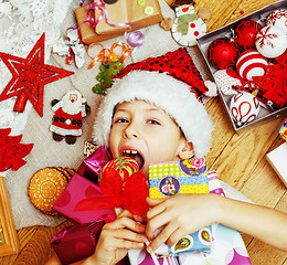 Image showing little cute boy with Christmas gifts at home. close up emotional