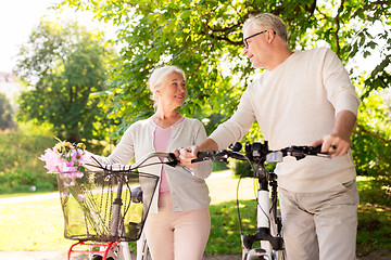 Image showing happy senior couple with bicycles at summer park