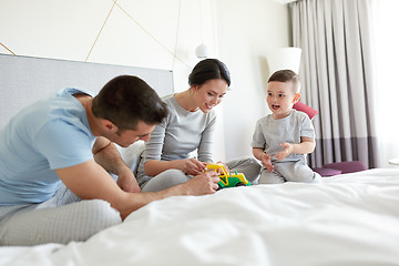 Image showing happy family in bed at home or hotel room