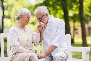 Image showing happy senior couple sitting on bench at park