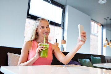 Image showing woman with smartphone taking selfie at restaurant