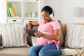 Image showing pregnant woman in headphones with tablet pc