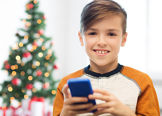 Image showing close up of happy boy with smartphone at christmas