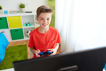 Image showing boy with gamepad playing video game on computer