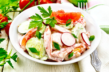 Image showing Salad from fresh vegetables and greens in plate on light board